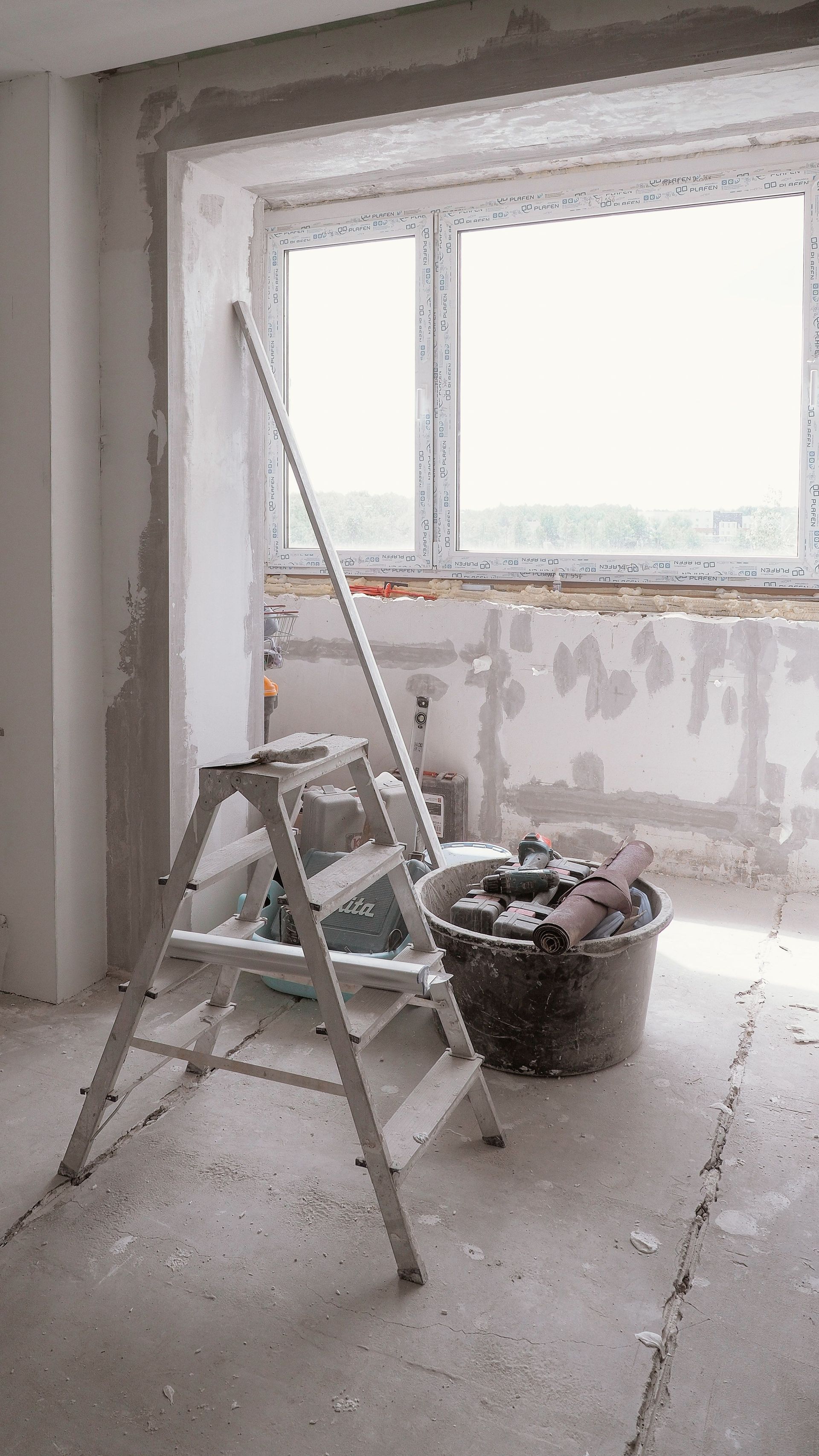 Sunlit room under renovation with tools and ladder, embodying modern DIY projects